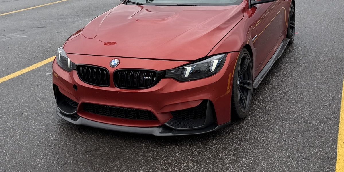 Orange BMW M4 coupe in a parking lot